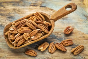 pecan nuts in a rustic scoop against a grunge wood background